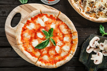 Canvas Print - Pizza Margherita with cheese, tomatoes and basil on dark wooden background. Vegetarian pizza, top view