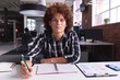 © Wavebreak Media - Portrait of mixed race businessman at the office sitting holding pencil looking to camera