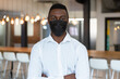 © Wavebreak Media - Portrait of casual african american businessman wearing face mask and looking to camera