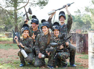 Canvas Print - Portrait of positive team of paintball players with marker guns ready for game outdoors