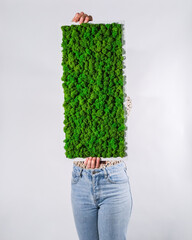 Poster - Vertical shot of a woman holding a deck with green plants growing on it