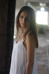 Poster - Vertical shot of a beautiful Caucasian brunette wearing a white dress