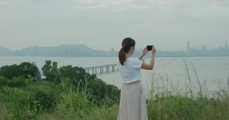 Sticker - Woman use cellphone to take photo on mountain