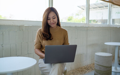 A beautiful young asian woman using and working on laptop computer