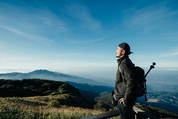 young man Thai boy Asian hipster men backpacker enjoying take a photo on beautiful landscape background 
scenery view jungle mountains green forest at Doi Inthanon National Park, Chiang Mai, Thailand.