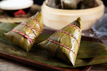 Closeup of zongzi on leaves on a tray on the table with a blurry background