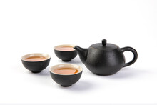 Closeup Shot Of A Black Teapot With Three Teacups Isolated On White Background