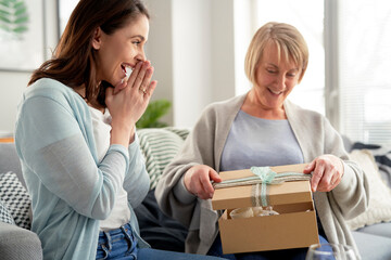 Excited woman waiting for mom to open the gift