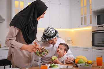 Wall Mural - Happy Muslim family eating together in kitchen