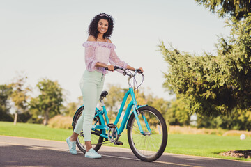 Wall Mural - Full size photo of optimistic brunette lady stand bicycle wear lilac top pants sneakers outside in park