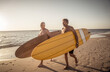 © SB Arts Media - Two senior surfers with surfboard having fun on empty remote beach enjoying retirement lifestyle