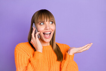 Poster - Photo of lady hold telephone chitchat look empty space wear orange pullover isolated violet color background