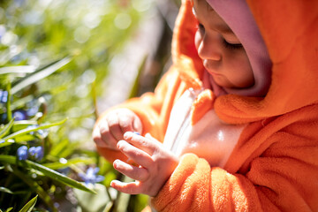 charming toddler with spring flowers outdoors in sunlight. artistic blur