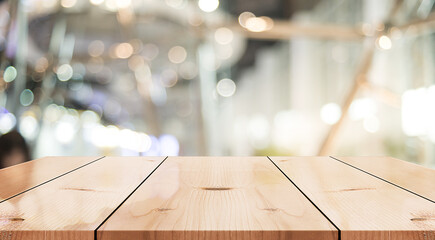 Empty wooden table top with lights bokeh on blur restaurant background