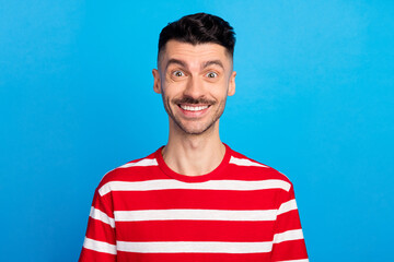 Sticker - Photo of attractive charming young man wear striped t-shirt smiling isolated blue color background