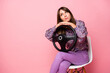 © deagreez - Photo of young unhappy upset sad girl looking copyspace sit chair hold steering wheel isolated on pink color background