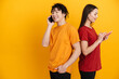 © Drobot Dean - Young multiracial couple smiling while using and talking on cellphones