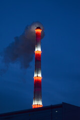 View of the power plant with a smoke of glowing chimney