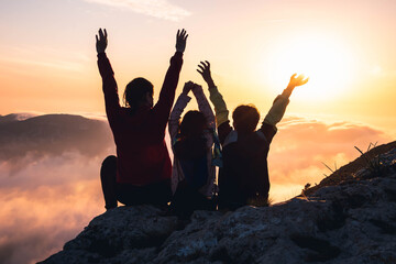 Madre e hijos disfrutando del atardecer desde lo más alto. Concepto de superación y éxito. 