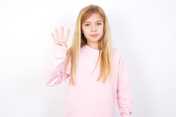 Wall Mural - beautiful caucasian little girl wearing pink hoodie over white background showing and pointing up with fingers number four while smiling confident and happy.