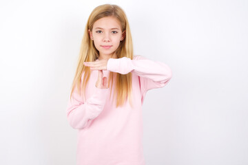 Wall Mural - beautiful caucasian little girl wearing pink hoodie over white background feels tired and bored, making a timeout gesture, needs to stop because of work stress, time concept.