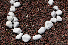 Circle Of Decorative White Pebbles On Tiny Red