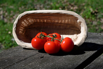 Sticker - several tomatoes on a wooden table outdoor in front of a basket