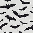 Halloween seamless patterns with flying bats. Vector illustration. Bat silhouettes isolated on grey background.