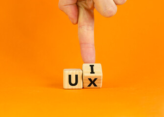 ux design or ui design. businessman turns a cube and changes words 'ux - user experience' to 'ui - u