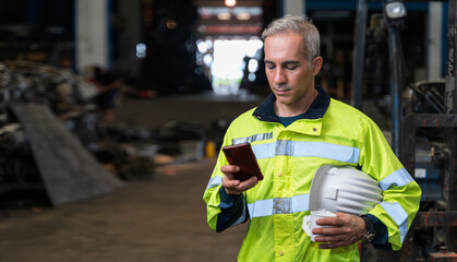 The chief engineer is using his phone and drinking coffee during the break. Lazy workers stop working and play on their phones, chats or social media. During work time at factory in worker concept.