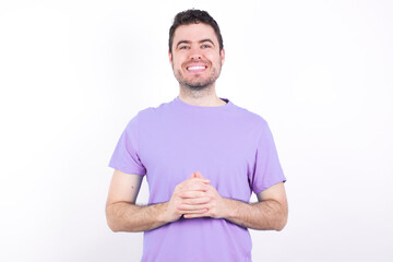 Wall Mural - Business Concept - Portrait of young handsome caucasian man wearing purple t-shirt against white background holding hands with confident face.