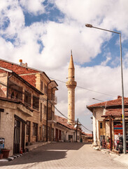 The street of an old Muslim town with stone buildings and a minaret