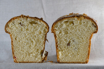 Two pieces of sweet cupcake with raisins on a gray linen background.