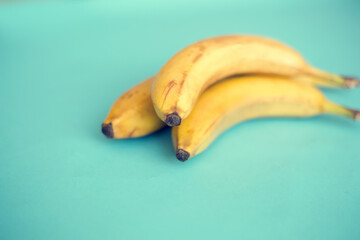 Three yellow bananas on a blue background.