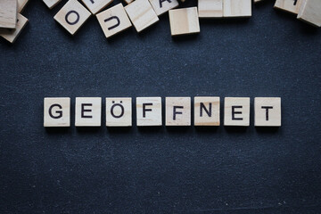 Wall Mural - Holzbuchstaben auf Tafel, geöffnet