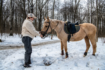 woman in a beige jacket and a cap with a horse of light coffee suit in a spring park 