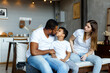 © Kanstantsinzzz - Loving black family relaxing at sofa in the morning, happy mixed race parents laughing cuddling having fun with cute little kid child son playing enjoying moments together. High quality photo