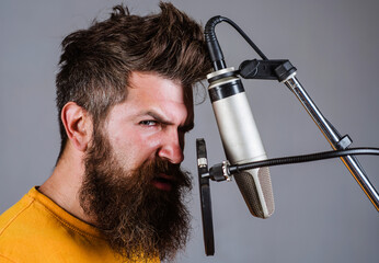 Man singing with microphone in studio. Bearded man in karaoke.