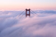 Golden Gate Bridge covered in clouds during the sunset in the evening in California