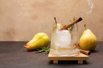 Wall Mural - Refreshing pear cocktail with tonic,smoking cinnamon stick and fresh rosemary on olive wooden board with fresh,sweet pears.Close up of tonic or detox drink.