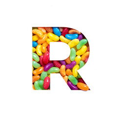 Letter R of alphabet made of rainbow jelly beans glucose candies and paper cut isolated on white. Festive typeface