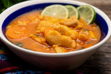 Sticker - Fish soup with vegetables on wooden background. Mexican food