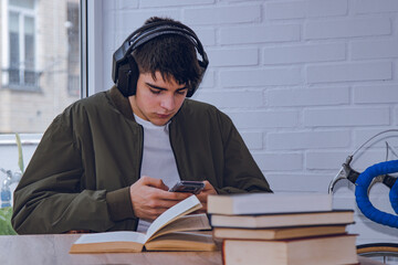 Wall Mural - student at home with headphones and mobile phone