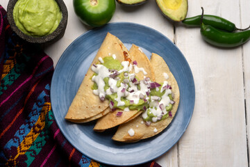 Wall Mural - Fried tacos with guacamole and sour cream on white background. Mexican food