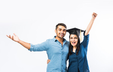 Indian Graduate female student wearing hat celebrating success with male friends