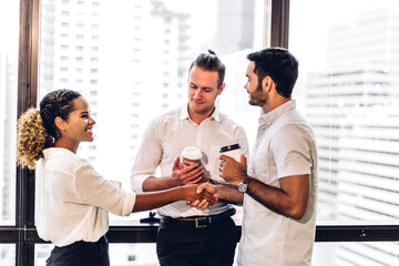 Wall Mural - Image two business partners successful handshake together in front of teamwork casual business winning success agreement in modern office.Partnership approval and teamwork