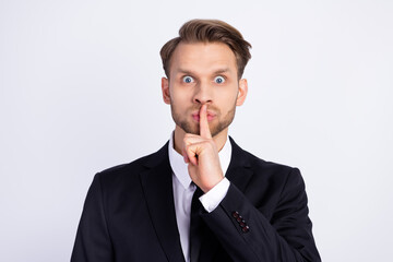 Photo of young man finger cover lips keep secret confidential shut up silence isolated over grey color background