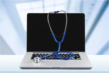 Poster - Modern laptop computer with stethoscope on the desk