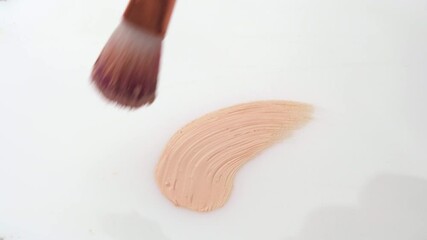 Wall Mural - Beige smear of make-up foundation cream with a brush on white background