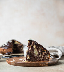 Wall Mural - Piece of homemade marble cake with chocolate glaze and nuts on wooden plate. Chocolate vanilla zebra pie.